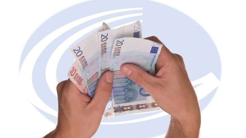 Hände, die Geldscheine halten, im Hintergrund Geseke-Logo