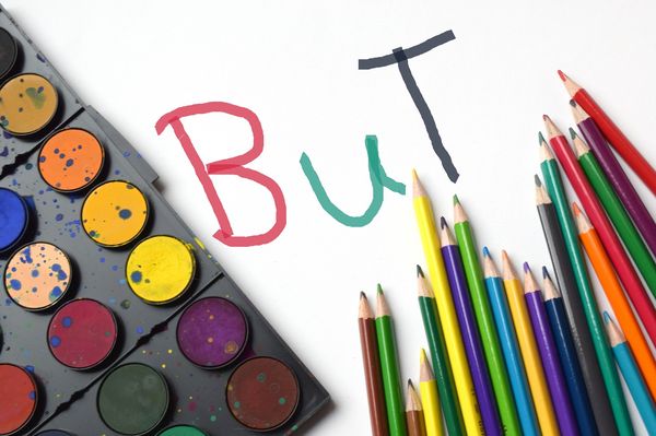 Farbkasten, Buntstifte und Schriftzug "BuT"