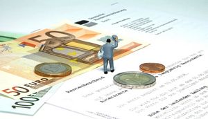 Erste Seite eines Rentenbescheides und darauf abgelegtes Bargeld