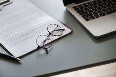 Papierunterlagen und Laptop auf einem Schreibtisch